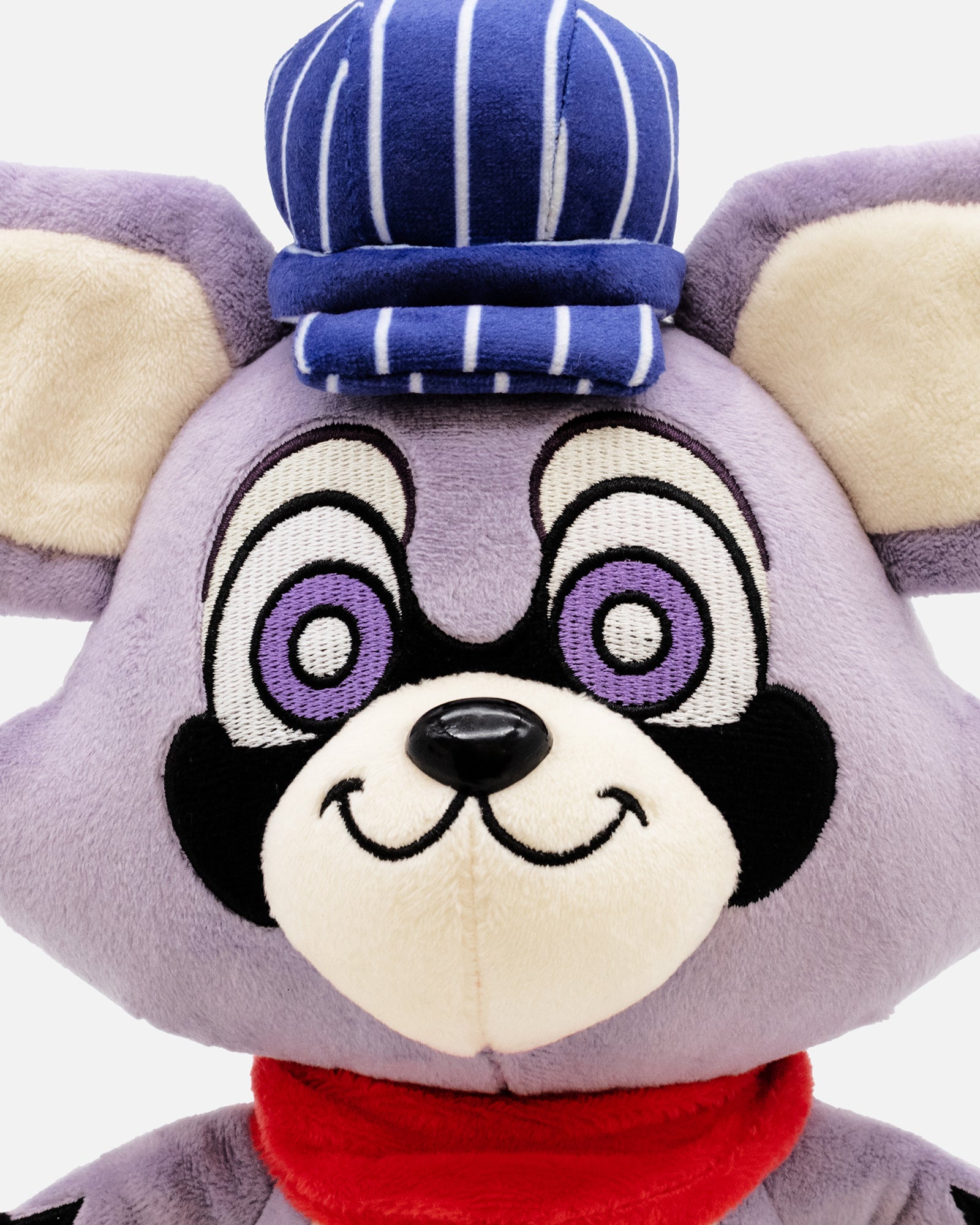 Plush toy with a purple face, purple eyes, and a red scarf on a white background