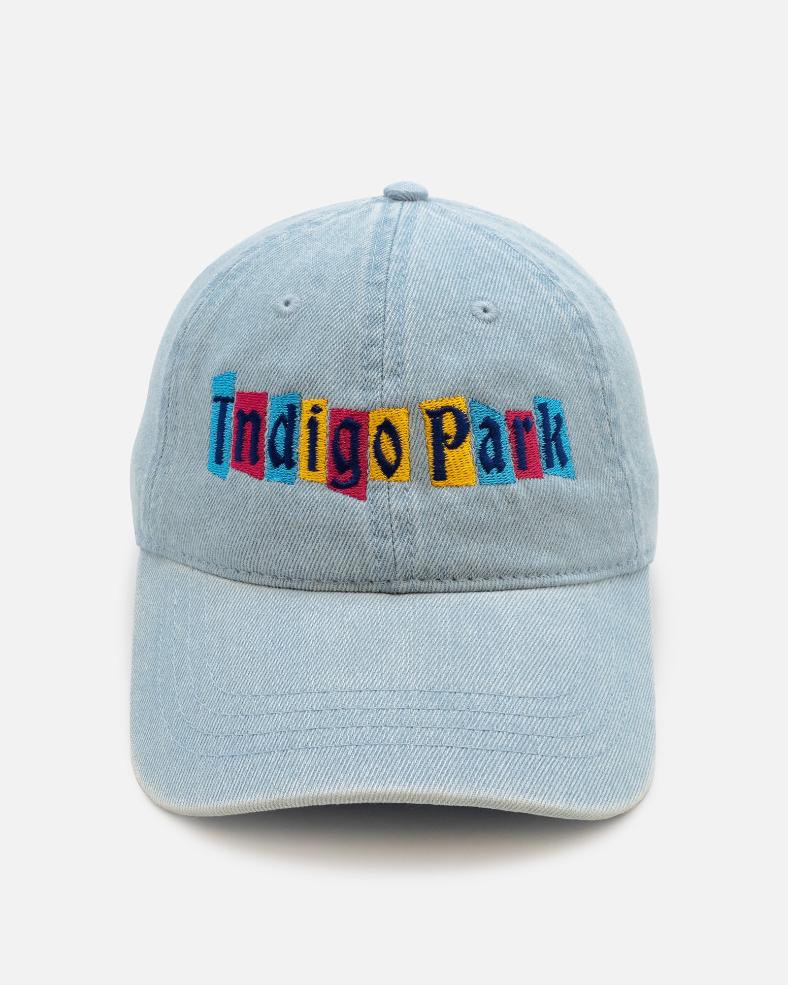 Light blue denim cap with 'Indigo Park' embroidered in colorful letters on a light gray background