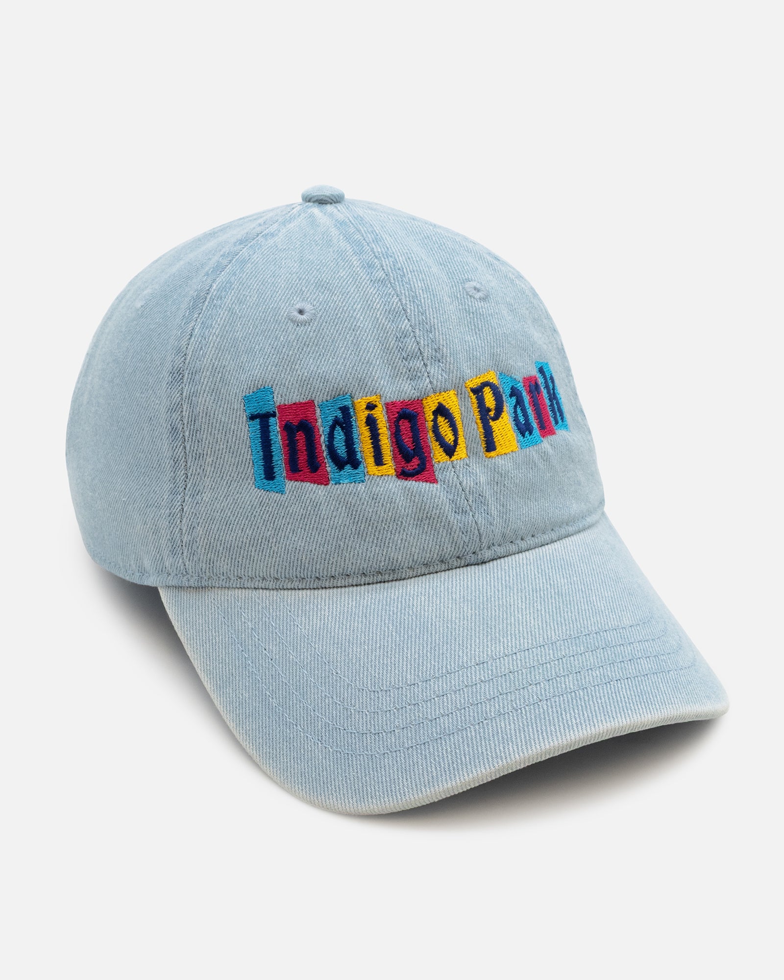 Light blue baseball cap with colorful 'Indigo Park' text on a light gray background